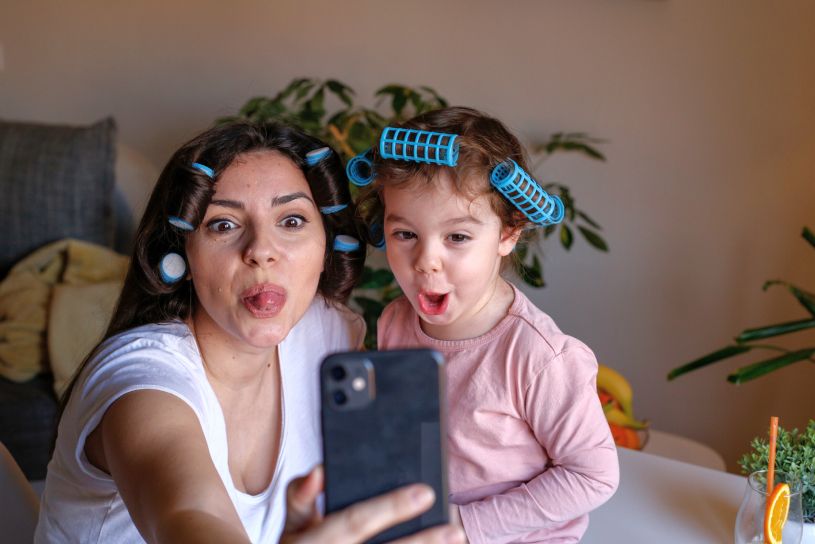 Mother and young daughter making silly faces for a selfie
